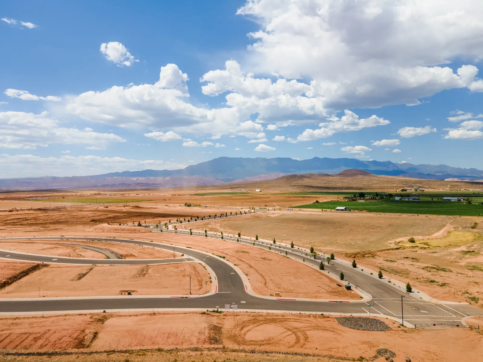 Aerial view of curving new streets with a mountain range on the horizon