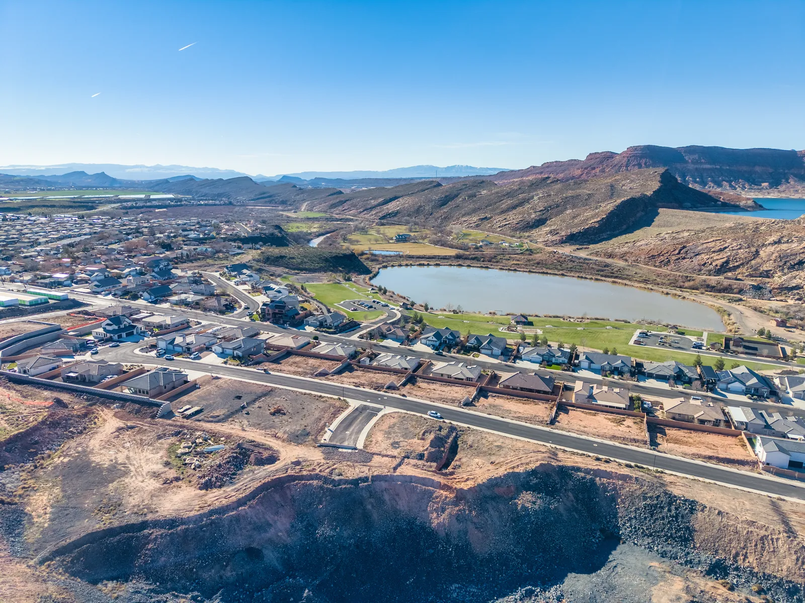 Aerial view of a Hurricane neighborhood around Grandpa's Pond, with red cliffs and mountains behind