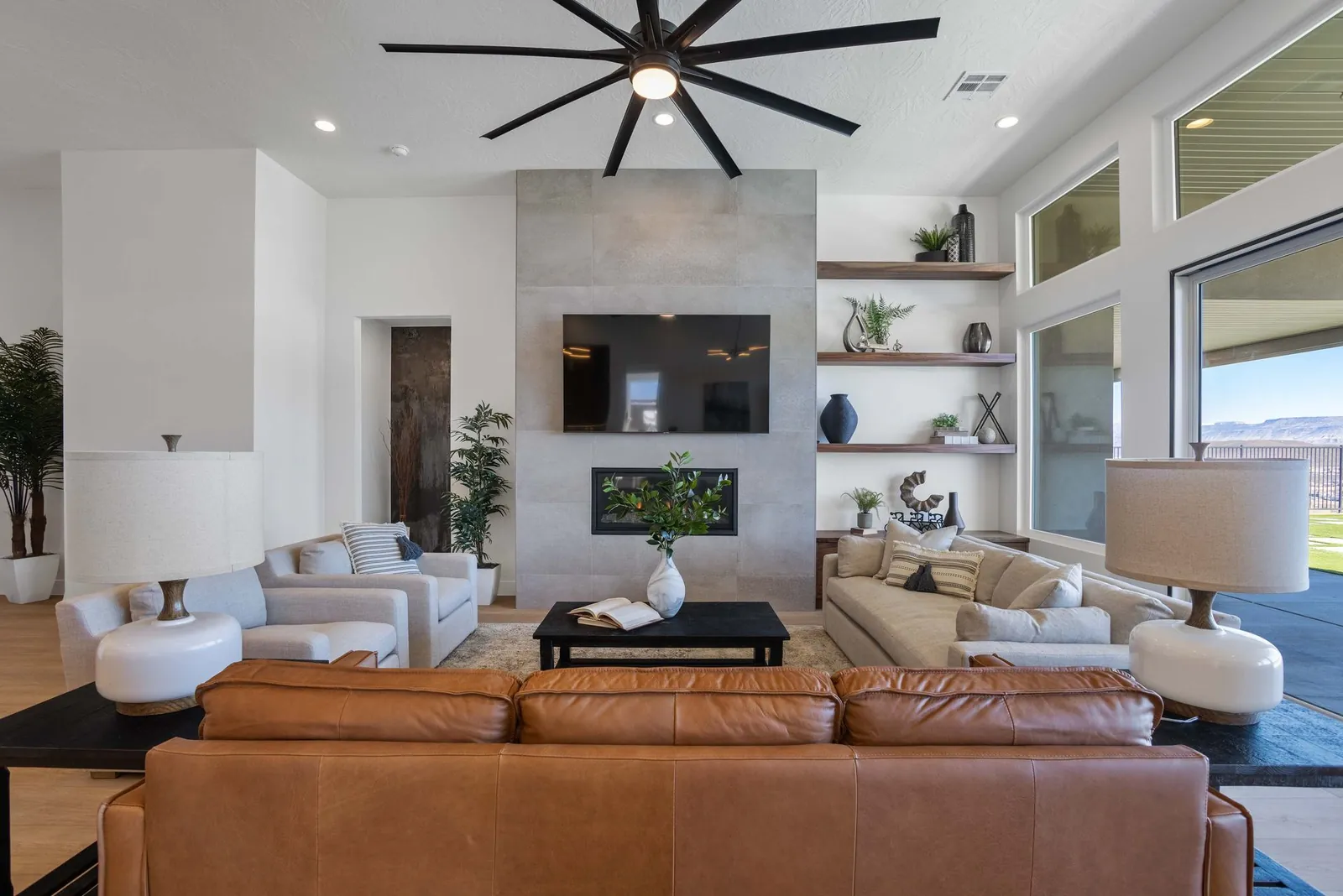Great room with a leather sofa and a tall fireplace wall